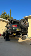 Load image into Gallery viewer, Godspeed Miata Rally/Offroad Coilover lift kit on mieep the lifted miata flexing on ramps
